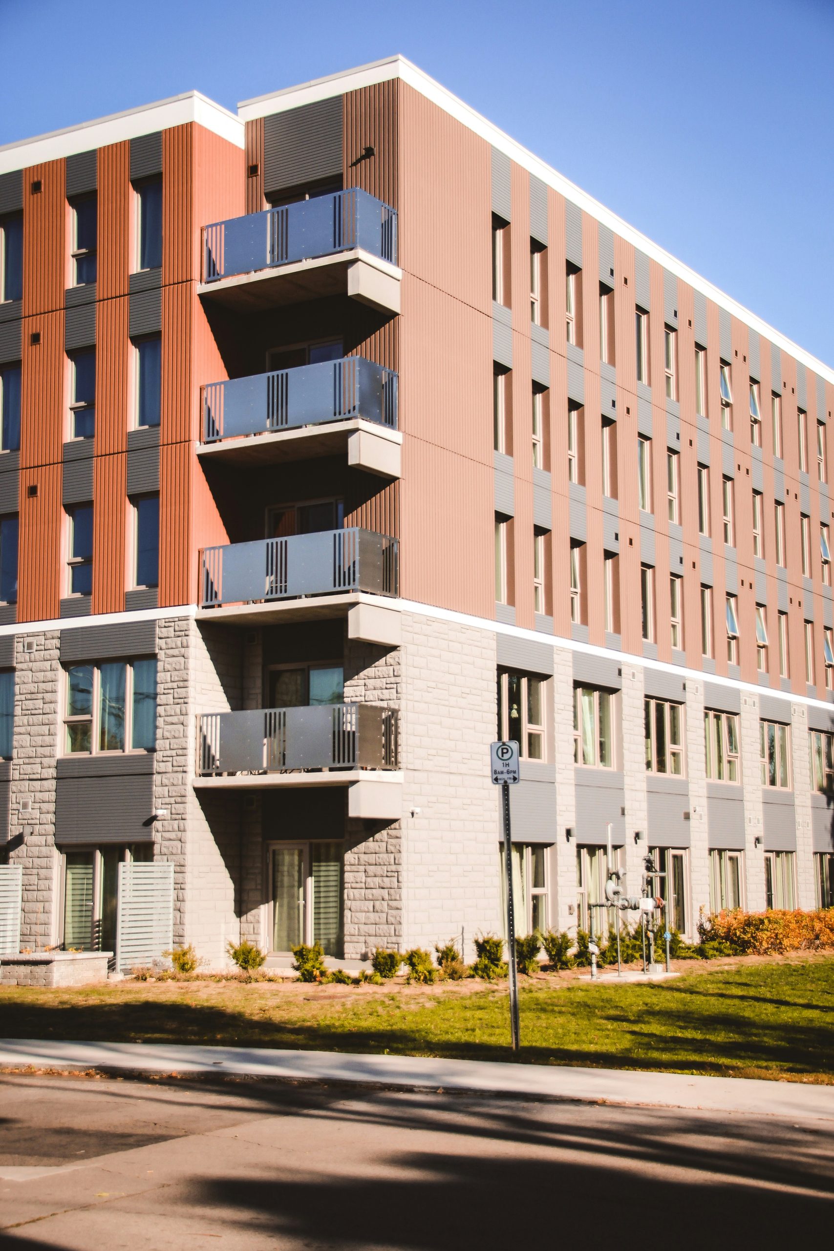 Apartment building with brown metal and light colored stone siding.