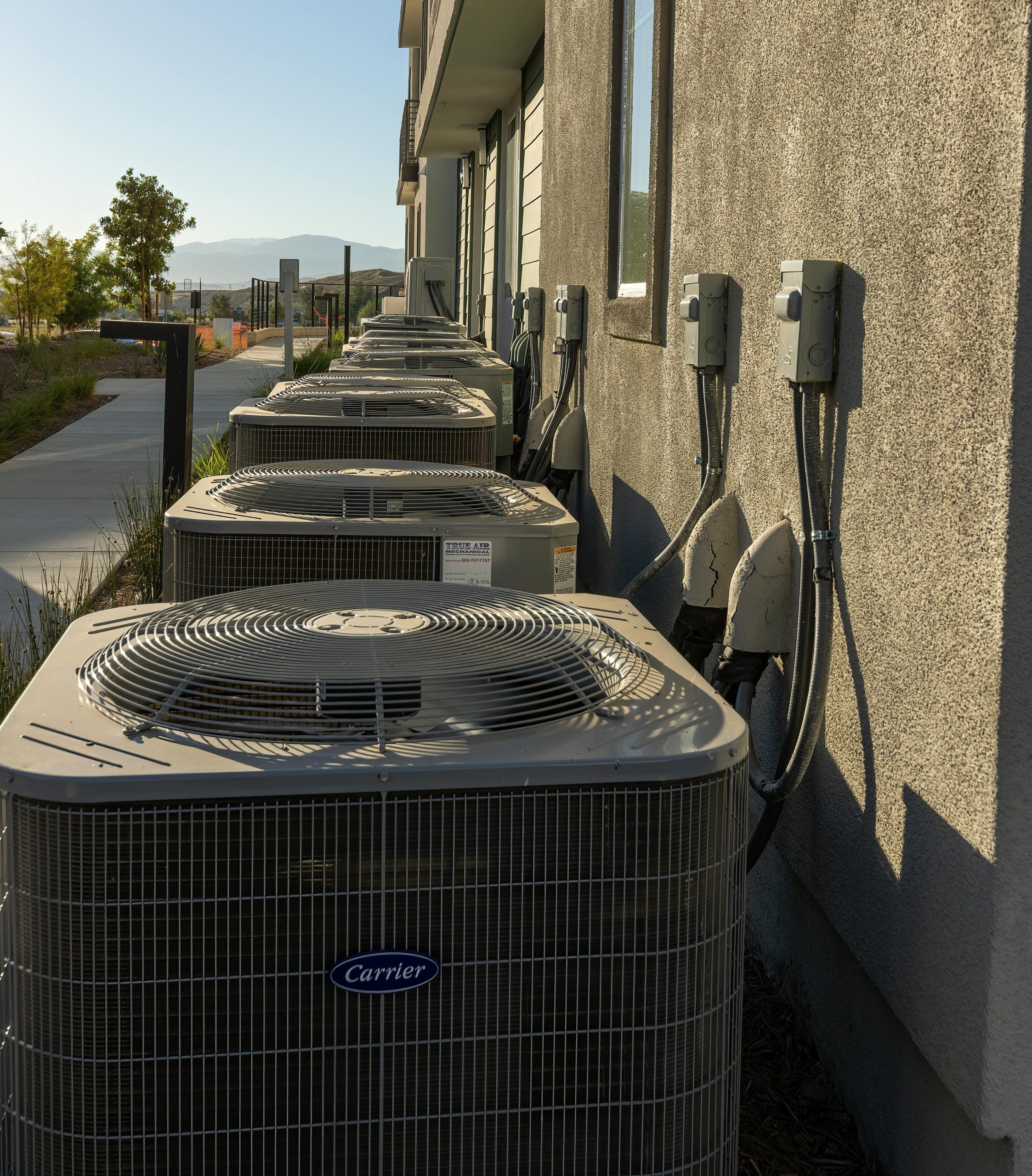 HVAC systems lined up against homes.