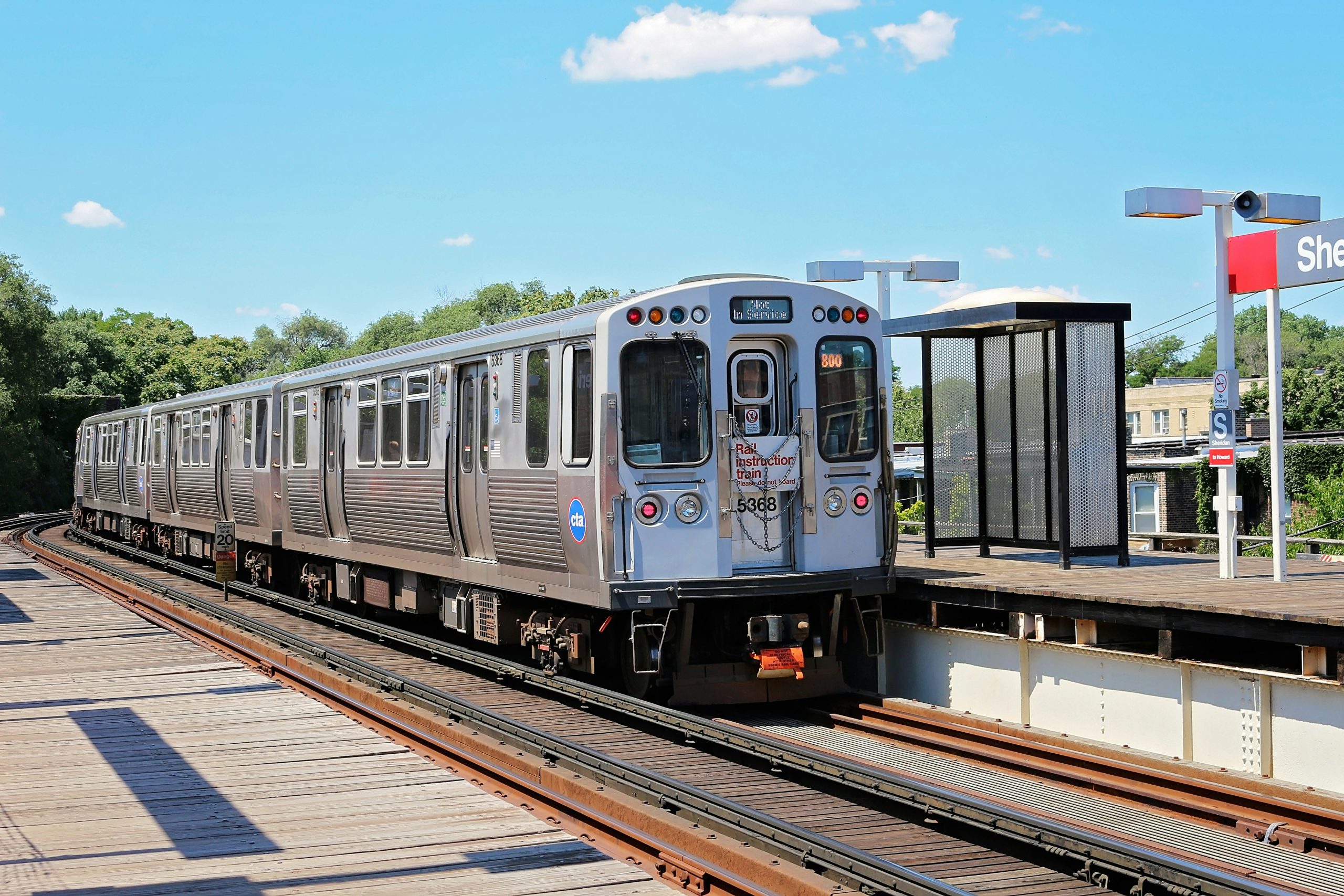 Metal train on a track at a stop.