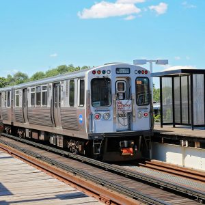 Metal train on a track at a stop.